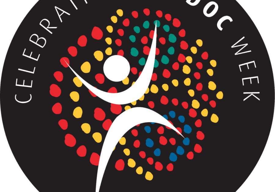 The NAIDOC Week logo: a black circle with a white figure in the centre surrounded by colourful red, yellow, green and blue dots, with white text that says 'celebrating NAIDOC week'.